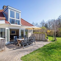 Terrasse mit Sitzgelegenheit im Bungalowpark Slufterduin - 't Oppertje, Ferienhaus in De Cocksdorp, Texel, umgeben von Natur.