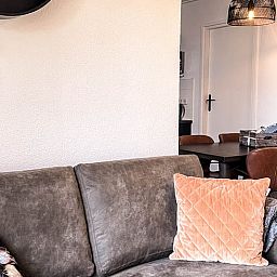 Gemuetliches Wohnzimmer im Ferienhaus in De Cocksdorp, Texel, mit bequemem Sofa und stilvoller Einrichtung auf den Watteninseln.