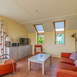 Gemuetliches Wohnzimmer des Ferienhauses in De Cocksdorp Texel mit komfortabler Sitzecke.