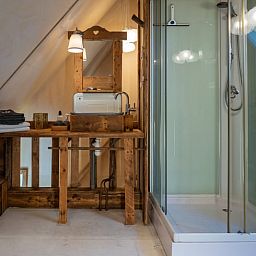 Aussenbereich des Ferienhauses in De Cocksdorp, Texel, mit Sonnenkollektoren und laendlichem Charme.