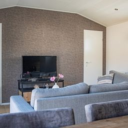 Stylish living room in Chalet Bregkoog 231, De Koog, Texel with television and modern furnishings at Chaletpark Bregkoog.