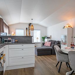 Offene Kueche im Chalet Bregkoog 52, De Koog Texel, mit modernen Geraeten und Essecke.