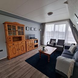 Gemuetliches Wohnzimmer in Appartements Anna - Noorderlicht - 13, De Koog, Texel, mit bequemer Sitzecke und viel Tageslicht.