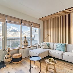 Stilvolle Sitzecke im Apartment Juliana 140 Island and Sea View, De Koog, Texel mit Panoramablick auf das Meer.