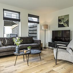 Stylish living room of Villa 41 in De Koog, Texel, with modern decor and lots of natural light.