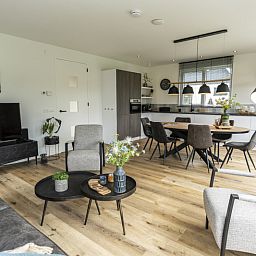 Open kitchen and dining area in Villa 41, vacation home in De Koog, Texel, with contemporary furniture.