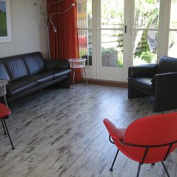 Living room of The Duinputter vacation home De Koog Texel with modern furnishings and garden view.