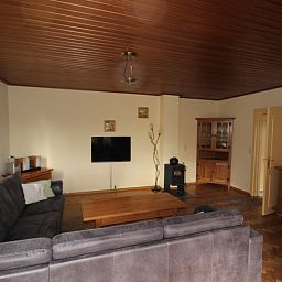 Interior space of Landhuis Landleven No. 81, vacation home in De Koog, Texel with spacious sitting area and wood stove.