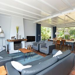 Gemuetliches Wohnzimmer in Orchismient 45 grosses Ferienhaus De Koog Texel mit bequemen Sitzgelegenheiten und Kamin.