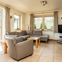 Cozy living room in Villa, De Koog, Texel with comfortable seating area and lots of natural light.