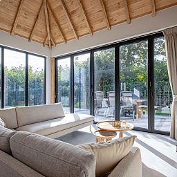 Bright living room of Villa Flo, Texel with large windows and views of the garden.
