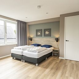 Spacious bedroom with large window in Villa 17, De Koog, Texel offers plenty of natural light and a serene atmosphere.