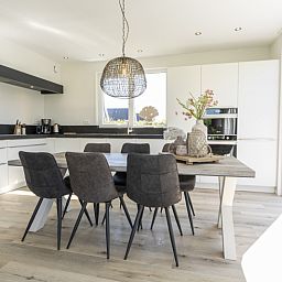 Dining room in Villa 35a, De Koog, Texel with modern kitchen and large table.