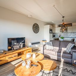 Moderne woonkamer met televisie in Appartement Juliana 048, gelegen in De Koog, Texel, met uitzicht op de omgeving.