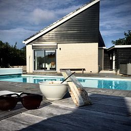 Sunny terrace with pool at Stappeland - Huize 100-1, vacation home in De Koog, Texel, ideal for relaxation.