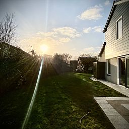Sunset over the garden of Stappeland - Huize 100-1, vacation home in De Koog, Texel, with serene nature.