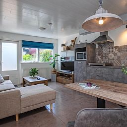 Stylish interior of Duo bungalow, vacation home in De Koog, Texel with open kitchen and sitting area.