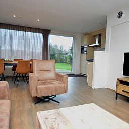 Bright living room in Epelaan 19 vacation home, De Koog, Texel, with dining area and garden view.
