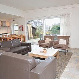 Spacious open living space in Epelaan 31, De Koog, Texel, with access to terrace and views of nature.