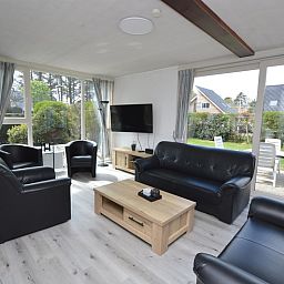 Ruime woonkamer in Orchismient 33 vakantiehuis De Koog Texel met uitzicht op tuin.