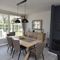 Eetkamer in Orchismient 33 vakantiehuis De Koog Texel met uitzicht op groene omgeving.