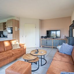 Open living space in Maaikeduinweg 13 vacation home, De Koog, Texel with modern kitchen and cozy sitting area for family stay.