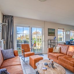 Bright living room in Maaikeduinweg 13 vacation home, De Koog, Texel with direct access to the terrace and views of nature.