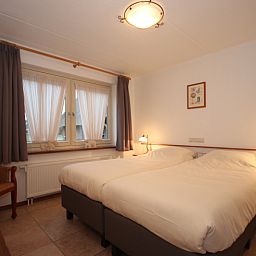 Slaapkamer in Villa, De Koog, Texel, met twee comfortabele bedden voor een goede nachtrust op de Waddeneilanden.