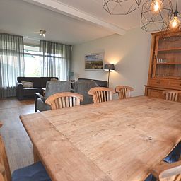 Open living room and dining area in vacation home Orchismient 27, De Koog, Texel, with rustic furnishings.
