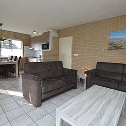 Modern decor in the living room of Holiday home Stappeland 207, De Koog, Texel with access to the kitchen.