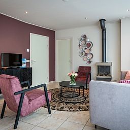 Moderne woonkamer met open haard in Bungalow 15a, De Koog, Texel.