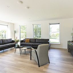 Bright living room in Villa 37a, De Koog, Texel, vacation home with comfortable seating area and views of nature.