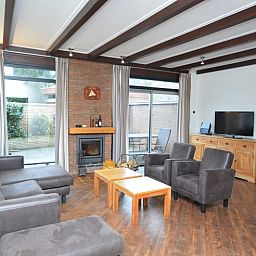 Cozy living room of Orchismient 28 De Koog Texel with fireplace and sitting area.