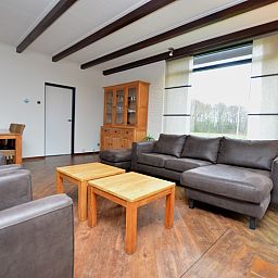 Spacious living room of vacation home Orchismient 28 De Koog Texel with wooden floor.