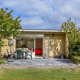 Cozy terrace of Bungalow 51 in Bungalowpark 't Luwe Land, De Koog, Texel, with garden furniture.