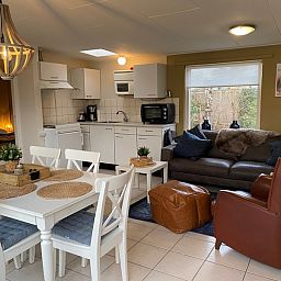 Modern kitchen and sitting area in Bungalow 51, Bungalowpark 't Luwe Land, De Koog, Texel, with comfortable furnishings.