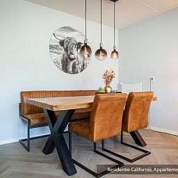 Dining area in Type 1 vacation home, De Koog, Texel with wooden table and modern lamps.