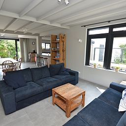 Geraeumiger, offener Wohnraum im Ferienhaus Ruijslaan 73, De Koog, Texel, mit moderner Einrichtung.