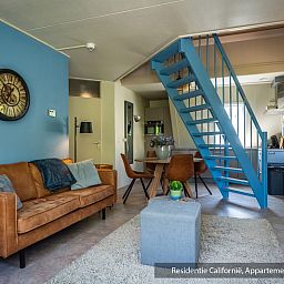 Modern open kitchen and dining area in Type 3B vacation home, De Koog, Texel, with stylish furnishings and blue accents.