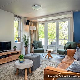 Bright living room of Type 3B vacation home in De Koog, Texel, with access to the terrace and a cozy atmosphere.