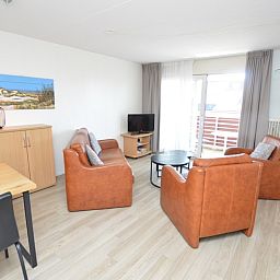 Helles Wohnzimmer im Motel Texel - Apartment 208/1L, De Koog, Texel, mit Balkonblick und moderner Einrichtung.