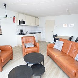 Offene Kueche im Motel Texel - Apartment 208/1L, De Koog, Texel, mit modernen Geraeten und einer gemuetlichen Sitzecke.