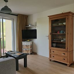 Cozy living space in De Duinpan - Duinhuisje Texel, De Koog, with wooden cupboard and modern furnishings.