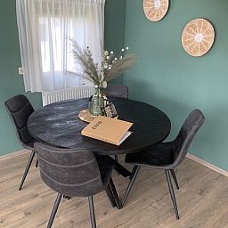 Dining area Chalet Bregkoog 203 in De Koog, Texel with round table and modern furnishings.