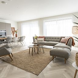 Stilvolles Wohnzimmer der Villa 19 in De Koog, Texel, mit bequemen Moebeln und viel Licht, ideal zum Entspannen.