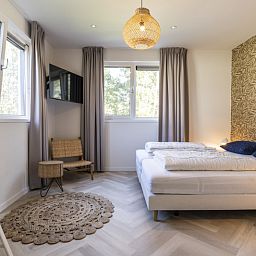 Schlafzimmer in der Villa 19, De Koog, Texel mit moderner Einrichtung und beruhigender Atmosphaere, ideal fuer eine gute Nachtruhe.