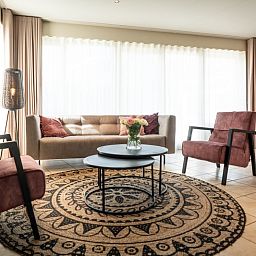 Bungalow 31 in De Koog, Texel mit hellem Wohnzimmer und moderner Einrichtung, ideal fuer einen erholsamen Ferienaufenthalt.