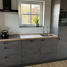 Dining room of Cottage in De Koog on Texel, featuring a rustic wooden table and art on the wall.