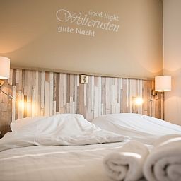 Cozy bedroom in Villa 5, De Koog, Texel, with comfortable beds and atmospheric lighting for a good night's sleep.