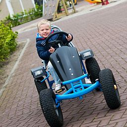 Child-friendly environment at Villa 5, De Koog, Texel, with fun on the go-kart for younger guests.
